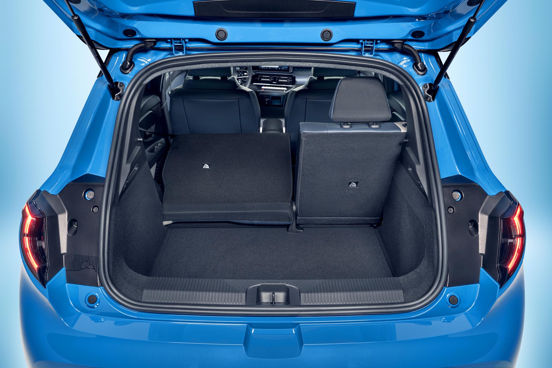 focused view of Micras empty trunk space with open trunk door and one collapsed seat